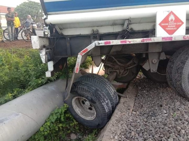 Foto - Ajaib! Hindari Kendaraan Lain, Truk Tangki Isuzu Giga Ini 'Lompat' ke Jalur Rel Kereta Api